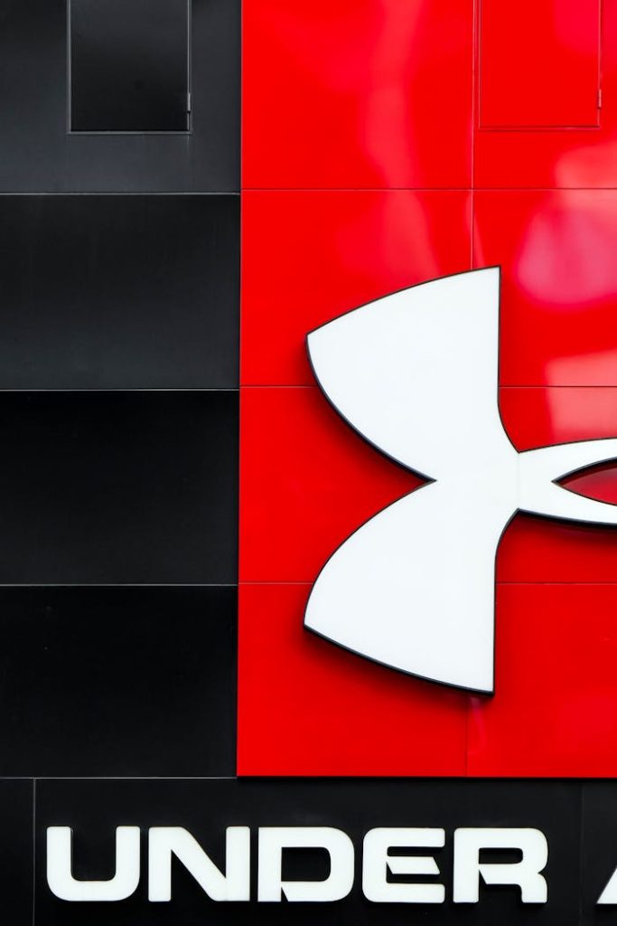 Close-up of Under Armour logo on a stylish red and black wall with modern graphic design elements.